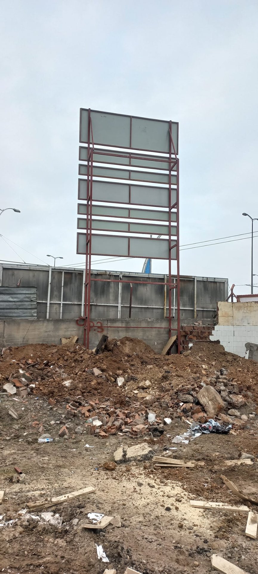 Enkaz sahasında henüz baskısız ruhsat tabelası iskeleti montajı